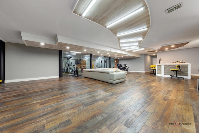 unfurnished living room featuring visible vents, hardwood / wood-style floors, recessed lighting, baseboards, and indoor bar