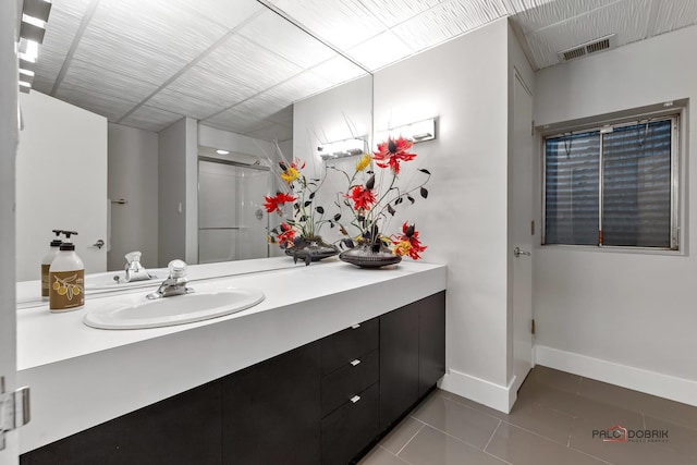 bathroom featuring vanity, visible vents, baseboards, a stall shower, and tile patterned floors