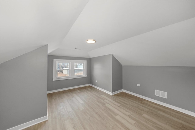 3012 N Knox Ave, Chicago, IL 60641 - additional living space with visible vents, light wood-type flooring, baseboards, and vaulted ceiling