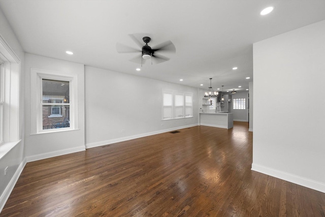 3012 N Knox Ave, Chicago, IL 60641 - unfurnished living room with visible vents, dark wood-type flooring, ceiling fan with notable chandelier, recessed lighting, and baseboards