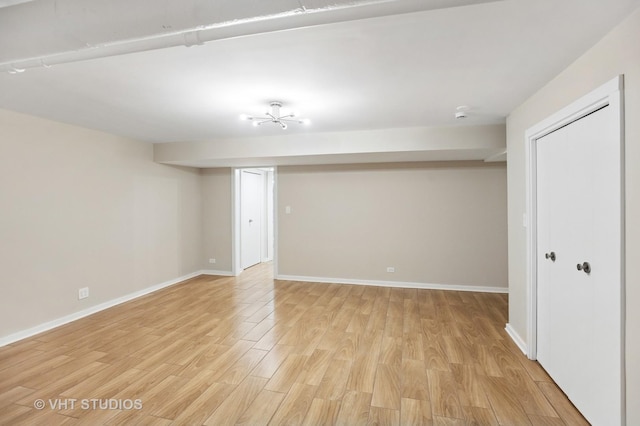 finished basement featuring light wood-style flooring and baseboards