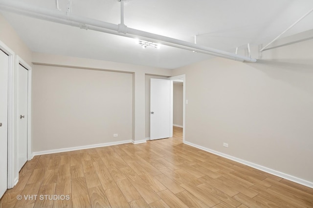 basement with light wood-style flooring and baseboards