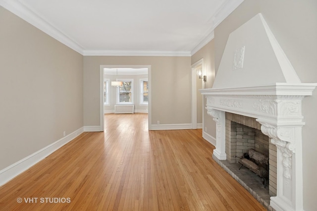 unfurnished living room featuring light wood-style flooring, a fireplace, ornamental molding, and baseboards