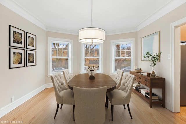 dining space with light wood-style flooring, crown molding, a chandelier, and baseboards
