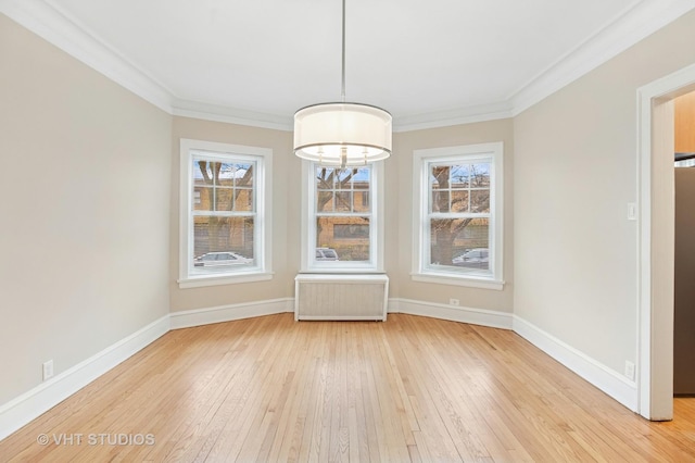 unfurnished dining area with baseboards, ornamental molding, a chandelier, radiator heating unit, and light wood-style floors
