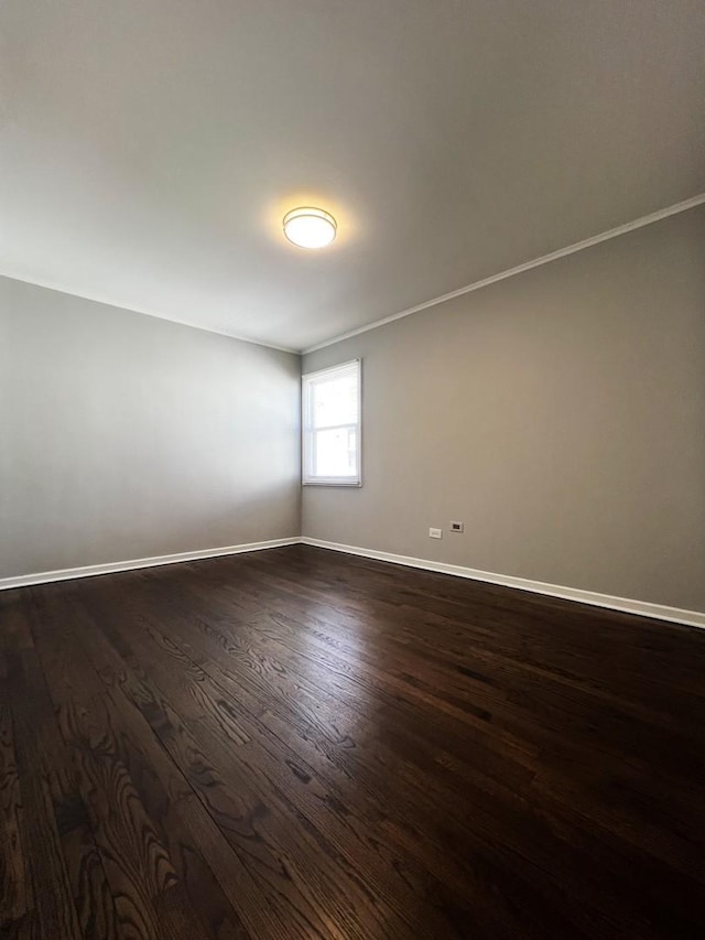 empty room with dark wood-type flooring and baseboards