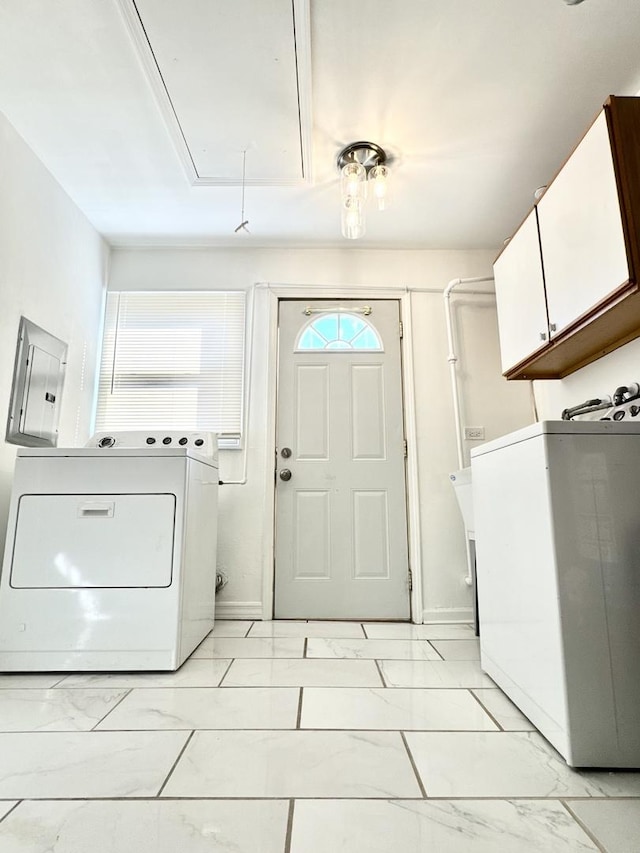 washroom with electric panel, washing machine and dryer, attic access, marble finish floor, and cabinet space