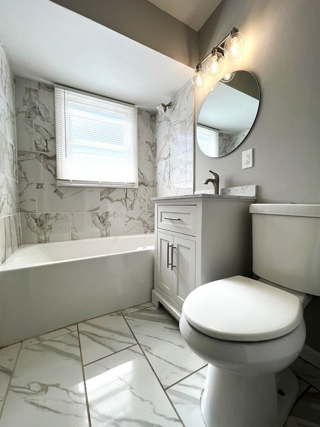 full bathroom featuring marble finish floor, a tub to relax in, toilet, and vanity
