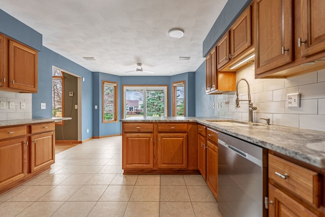 kitchen with a sink, backsplash, brown cabinets, and dishwasher