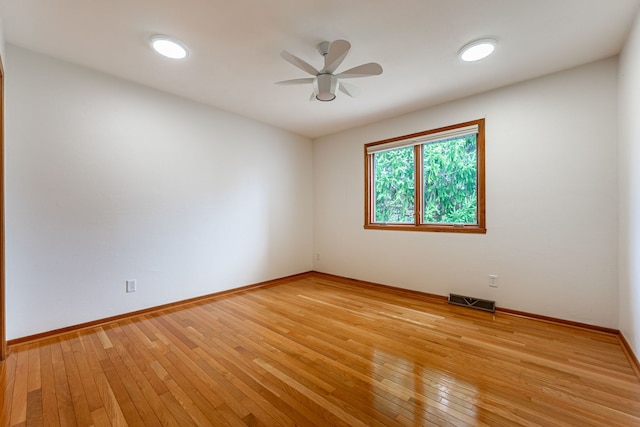 unfurnished room with light wood-style floors, baseboards, ceiling fan, and visible vents