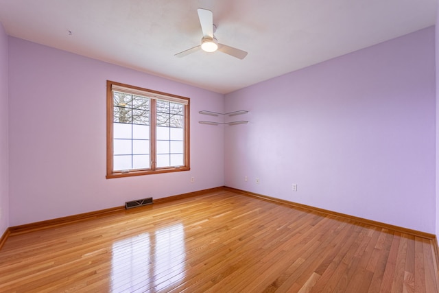unfurnished room with baseboards, ceiling fan, visible vents, and light wood-style flooring