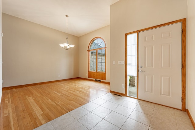 entrance foyer with light wood-style floors, baseboards, a chandelier, and visible vents