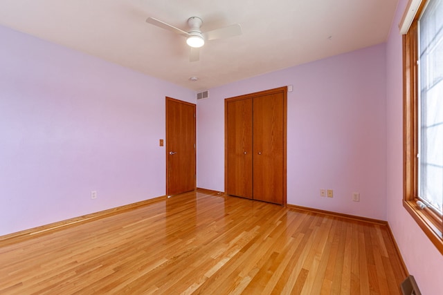 unfurnished bedroom featuring visible vents, light wood-style flooring, baseboards, and multiple windows