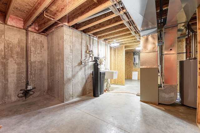 unfinished below grade area with a sink and gas water heater