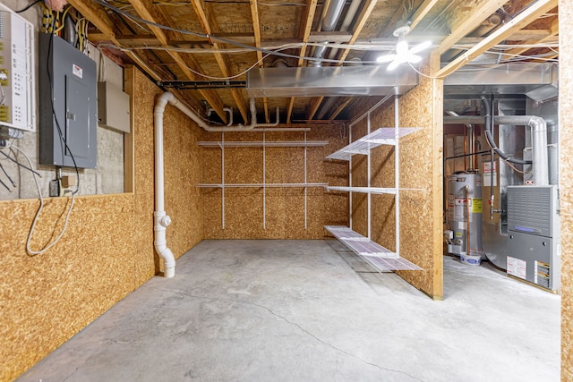unfinished below grade area featuring heating unit, water heater, and electric panel