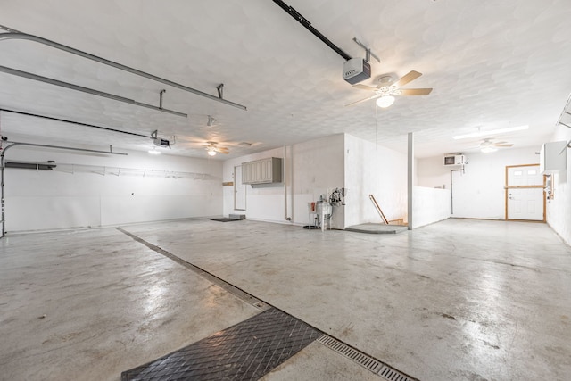 garage featuring ceiling fan, a garage door opener, and a wall mounted air conditioner