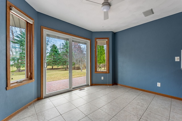 unfurnished room with baseboards, ceiling fan, and light tile patterned floors