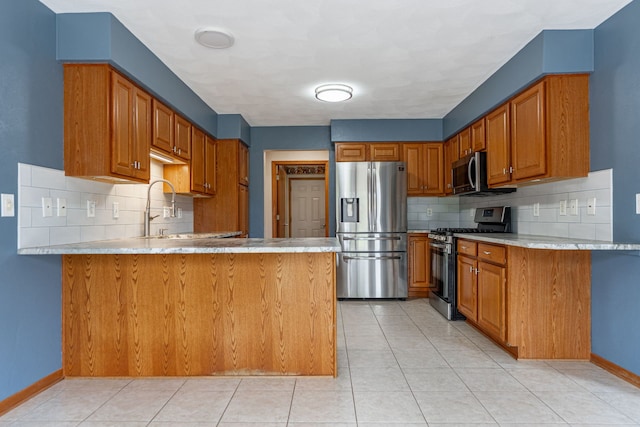 kitchen featuring stainless steel appliances, brown cabinetry, a peninsula, and tasteful backsplash