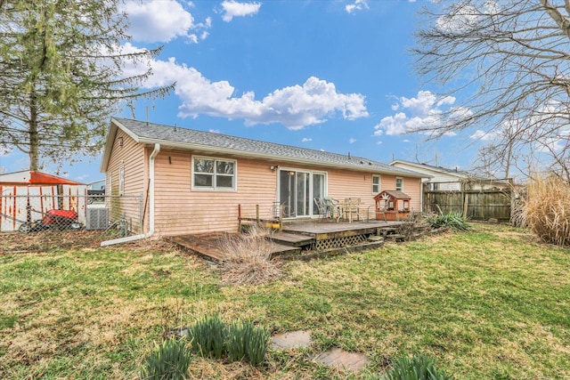 rear view of house with fence, central AC, a yard, and a wooden deck