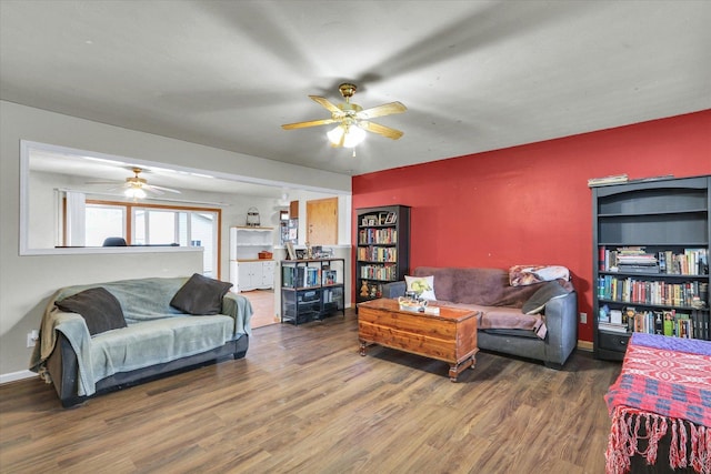 living area featuring baseboards, wood finished floors, and a ceiling fan