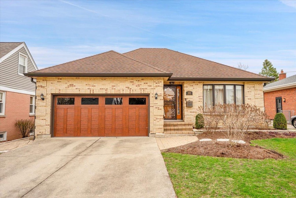 315 N Wille St, Mount Prospect, IL 60056 - view of front facade featuring roof with shingles, brick siding, driveway, and an attached garage