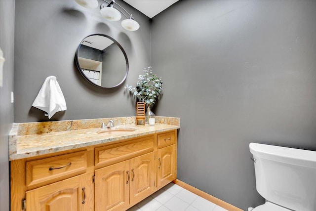 bathroom featuring toilet, vanity, baseboards, and tile patterned flooring