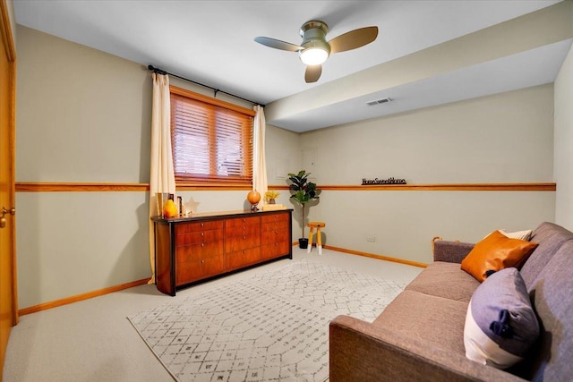 living area featuring carpet floors, baseboards, a ceiling fan, and visible vents