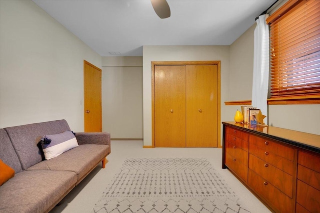 interior space with visible vents, ceiling fan, and light carpet