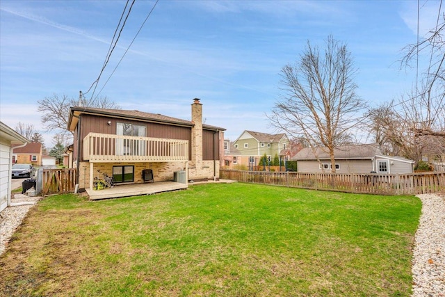 back of house featuring a yard, a fenced backyard, a wooden deck, and a chimney