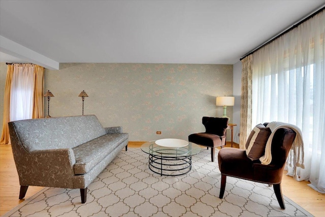 living area featuring wood finished floors and wallpapered walls