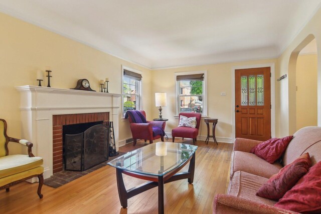 5842 N Kingsdale Ave, Chicago, IL 60646 - living room featuring hardwood / wood-style flooring, a fireplace, arched walkways, and baseboards