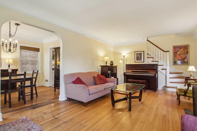 5842 N Kingsdale Ave, Chicago, IL 60646 - living room featuring arched walkways, light wood-style floors, ornamental molding, stairs, and a chandelier