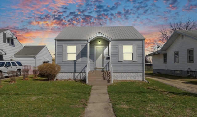 bungalow-style house with metal roof, a front yard, and fence