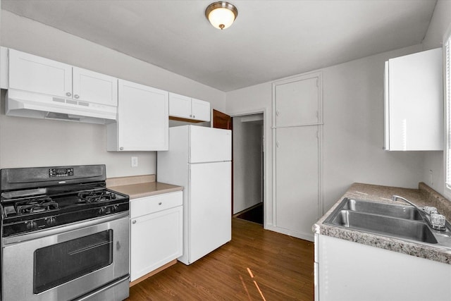 kitchen featuring under cabinet range hood, freestanding refrigerator, stainless steel gas stove, white cabinets, and a sink