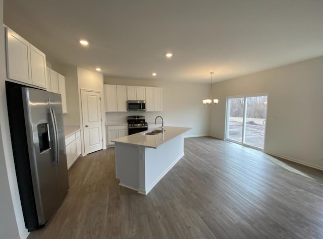 32004 Savannah Dr, Lakemoor, IL 60051 - kitchen with stainless steel appliances, a chandelier, dark wood-style floors, white cabinetry, and a kitchen island with sink