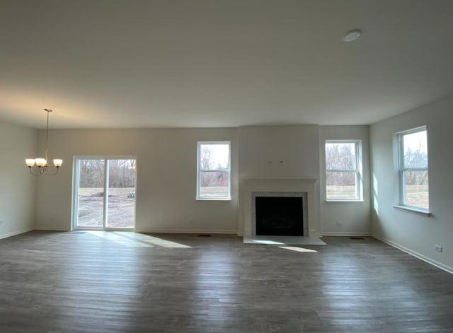 32004 Savannah Dr, Lakemoor, IL 60051 - unfurnished living room featuring a chandelier, a fireplace with flush hearth, and dark wood-type flooring