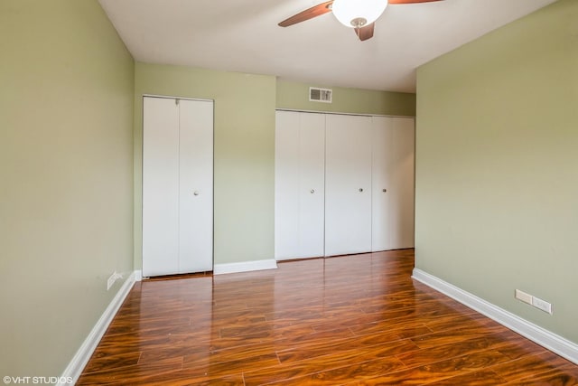 675 Grove Dr Unit 204, Elk Grove Village, IL 60007 - unfurnished bedroom with wood finished floors, two closets, baseboards, visible vents, and a ceiling fan