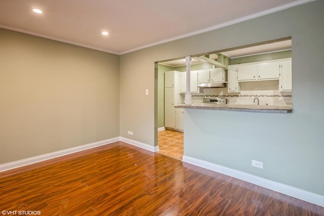 675 Grove Dr Unit 204, Elk Grove Village, IL 60007 - unfurnished living room with crown molding, ornate columns, baseboards, and dark wood finished floors