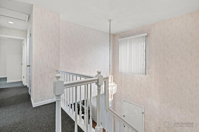 interior space featuring baseboards, an upstairs landing, and carpet flooring