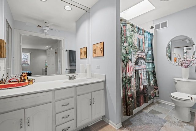 bathroom with vanity, a ceiling fan, visible vents, baseboards, and toilet