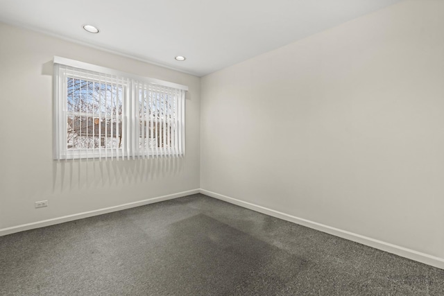 spare room with recessed lighting, baseboards, and dark carpet