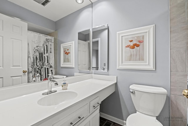 bathroom featuring vanity, curtained shower, toilet, and baseboards