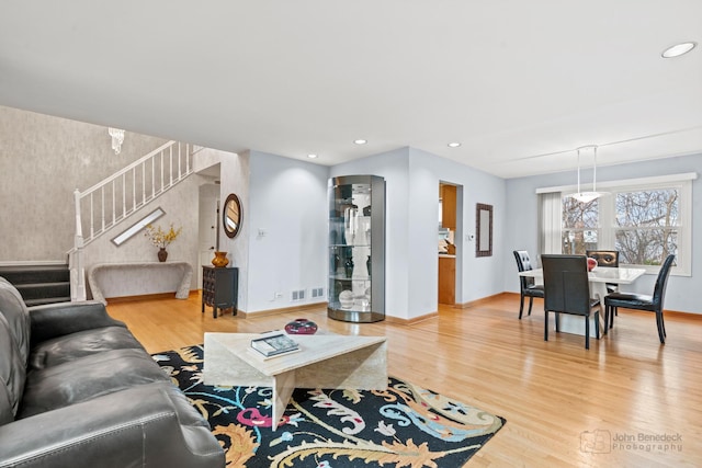 living room featuring visible vents, wood finished floors, recessed lighting, baseboards, and stairs