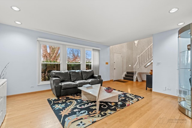 living room with stairway, baseboards, and wood finished floors