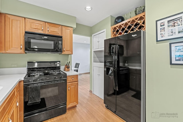 kitchen featuring recessed lighting, black appliances, light wood-type flooring, and light countertops