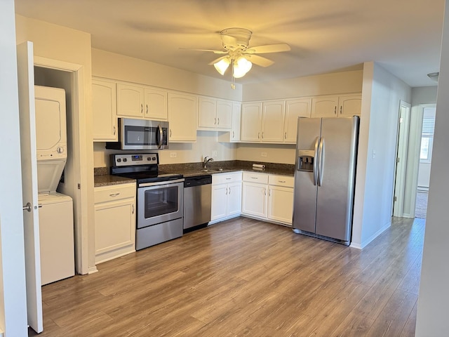 2356 Gaylord Rd Unit 2D, Crest Hill, IL 60403 - kitchen with appliances with stainless steel finishes, estacked washer and dryer, white cabinetry, ceiling fan, and dark countertops