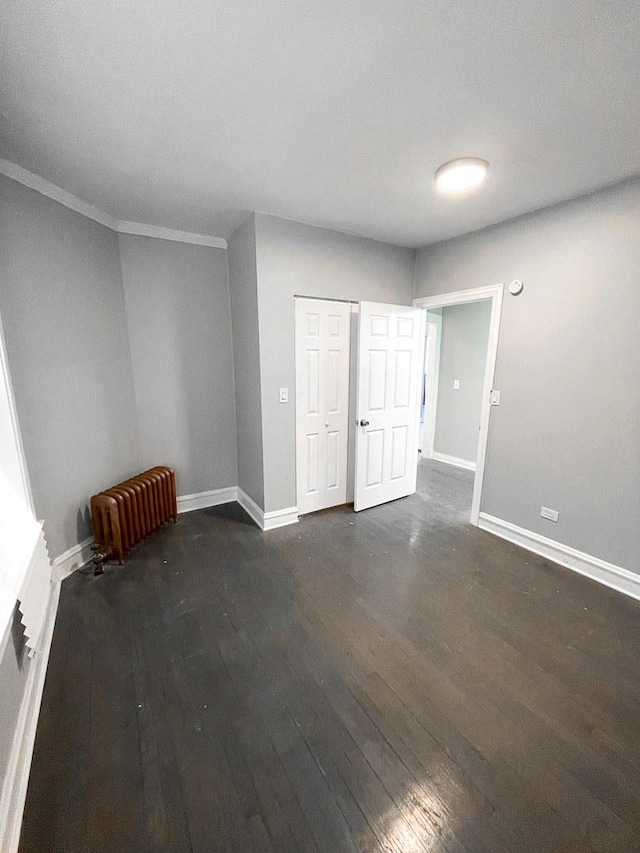 6634 S Greenwood Ave Unit 3B, Chicago, IL 60637 - spare room featuring dark wood finished floors, radiator heating unit, baseboards, and ornamental molding