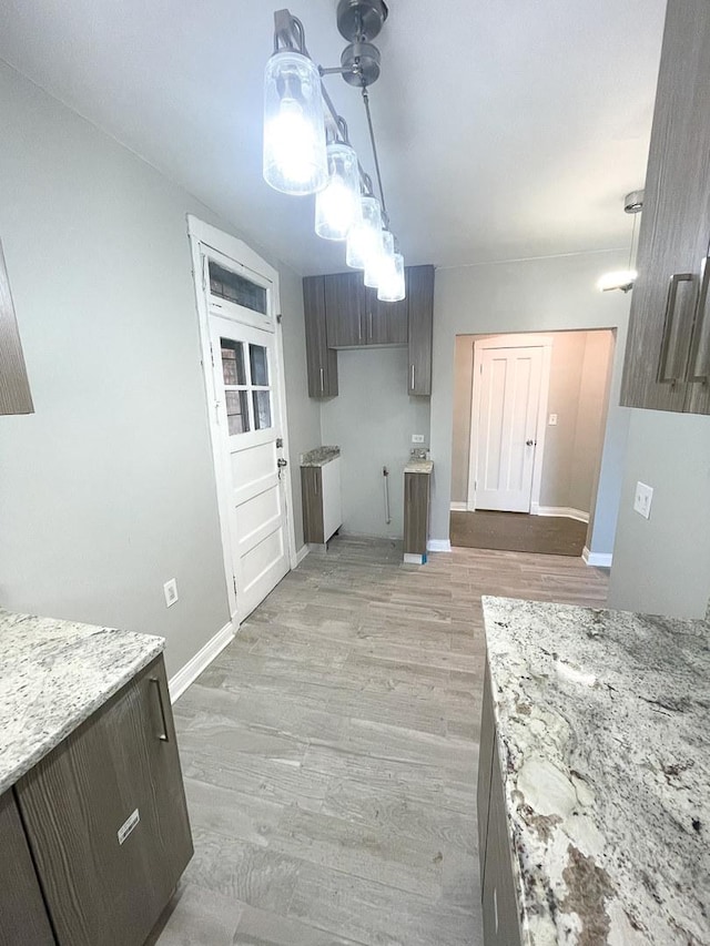 6634 S Greenwood Ave Unit 3B, Chicago, IL 60637 - kitchen with baseboards, light wood-style floors, and light stone countertops