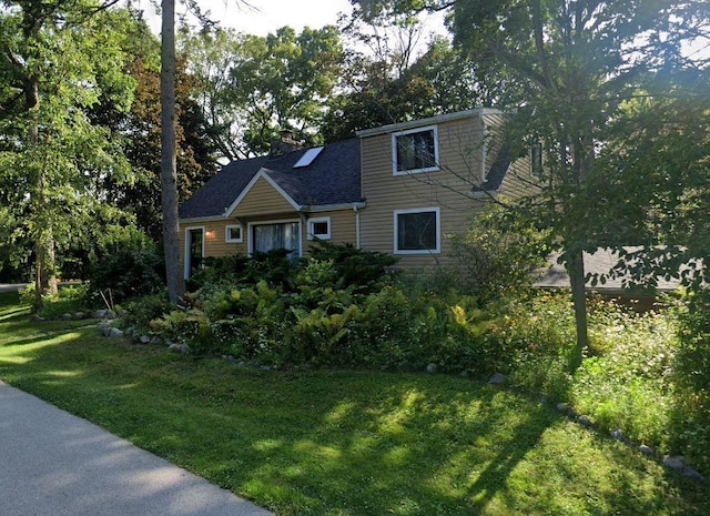 view of front of house featuring a chimney and a front yard