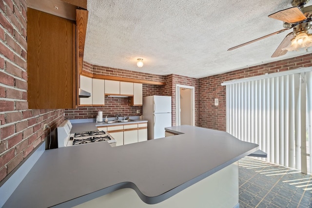 17433 Appletree Dr, Hazel Crest, IL 60429 - kitchen featuring white appliances, brick wall, ceiling fan, a peninsula, and wall chimney exhaust hood
